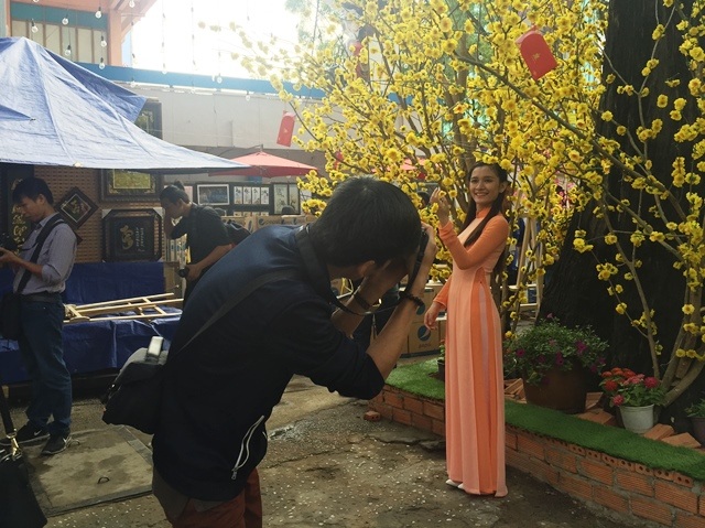 
Từ 7g sáng, khi các gian hàng của ông đồ còn chưa mở các bạn trẻ đã đến sớm tạo dáng bên hoa mai
