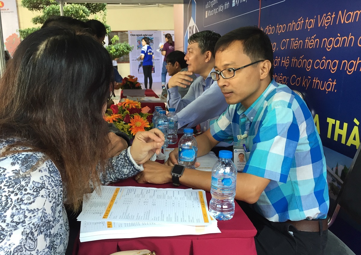 ĐH Bách khoa TPHCM công bố điểm chuẩn, thủ khoa đạt 28,05 điểm - 1 TS Lê Chí Thông (bên phải) tư vấn cho phụ huynh về ngành học
