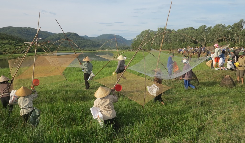 Sau hiệu lệnh hàng trăm người cùng tràn xuống đầm để trổ tài đánh cá của bản thân với tất cả những dụng cụ mang theo.