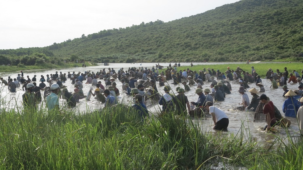Hàng trăm người chen chân dưới đầm đánh cá.
