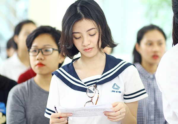 Cô bạn tranh thủ xem lại các thông tin dự thi trong khi xếp hàng