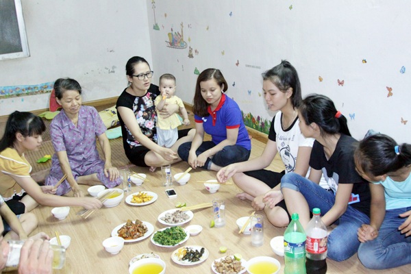 Cô giáo giúp đỡ trò nghèo ăn ở trong suốt kỳ thi - 2 Cô giáo Thúy (bế con) ngồi ăn cơm cùng với các học trò của mình.
