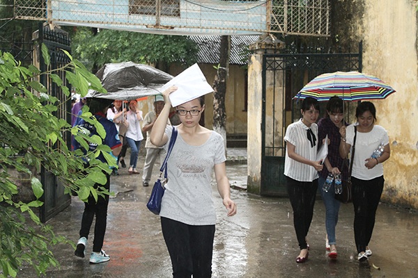 Thí sinh dùng bao đựng giấy tờ để che mưa