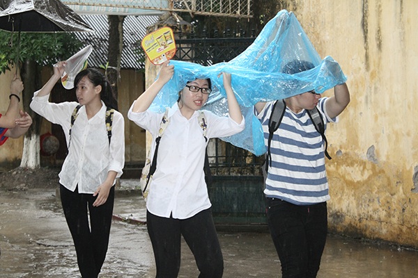 
Thí sinh đội mưa tới làm giấy tờ tại điểm thi Đại học Thủy lợi (Hà Nội). (Ảnh: Mai Châm)
