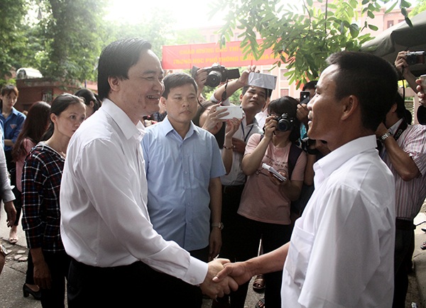 Bộ trưởng Phùng Xuân Nhạ bắt tay động viên anh Nguyễn Văn Tiên - phụ huynh thí sinh Nguyễn Văn Triệu