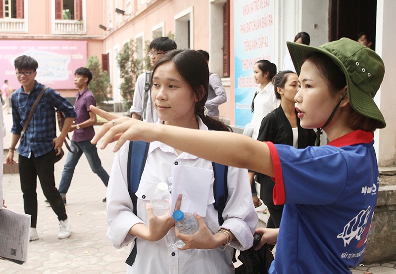 Nụ cười áo xanh tình nguyện xua tan mệt nhọc mùa thi cử - 4 SVTN chỉ đường cho thí sinh dự thi (ảnh: Mai Châm)
