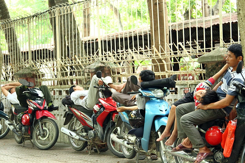 Ở một góc yên tĩnh sát hàng rào, các ông bố nằm nghỉ ngay trên xe máy.