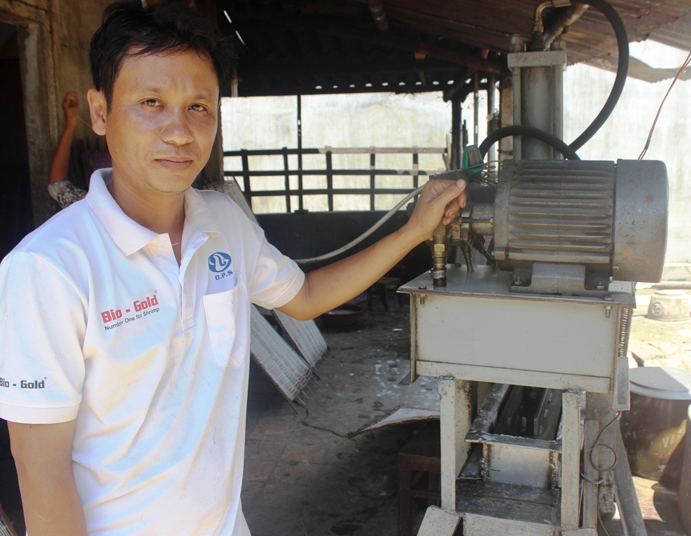 Anh Thanh bên chiếc máy làm bún được gắn thiết bị mắt quang học tự động do anh mày mò nghiên cứu chế tạo ra