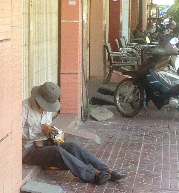 Sau buổi hành nghề cụ ông ngồi đếm tiền (ảnh chụp trưa 23/4/2016, trên đường Phạm Hùng, TP Quy Nhơn)