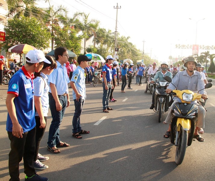 
Tình nguyện viên tại điểm thi Đại học Quy Nhơn (Bình Định) dàn hàng phân luồng giao thông đảm bảo cho an toàn cho thí sinh và người nhà. (Ảnh: Doãn Công)
