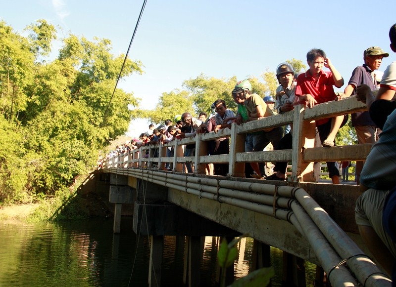 Đông đảo người dân hiếu kỳ đứng trên cầu xem lực lượng cứu hộ tìm kiếm người phụ nữ nghi ngờ nhảy cầu tự tử
