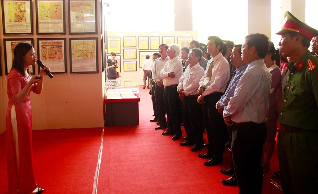 Lãnh đạo các Bộ, tỉnh cùng đông đảo cán bộ, chiến sĩ chăm chú lắng nghe hướng dẫn thuyết trình về những tài liệu trưng bày tại triển lãm