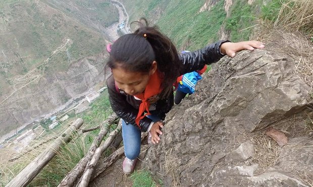 Hãi hùng cảnh học sinh Trung Quốc leo vách đá đi học - 4 Một học sinh phải bám vào vách đá để không bị trượt chân khi leo (Ảnh: Chen Jie)