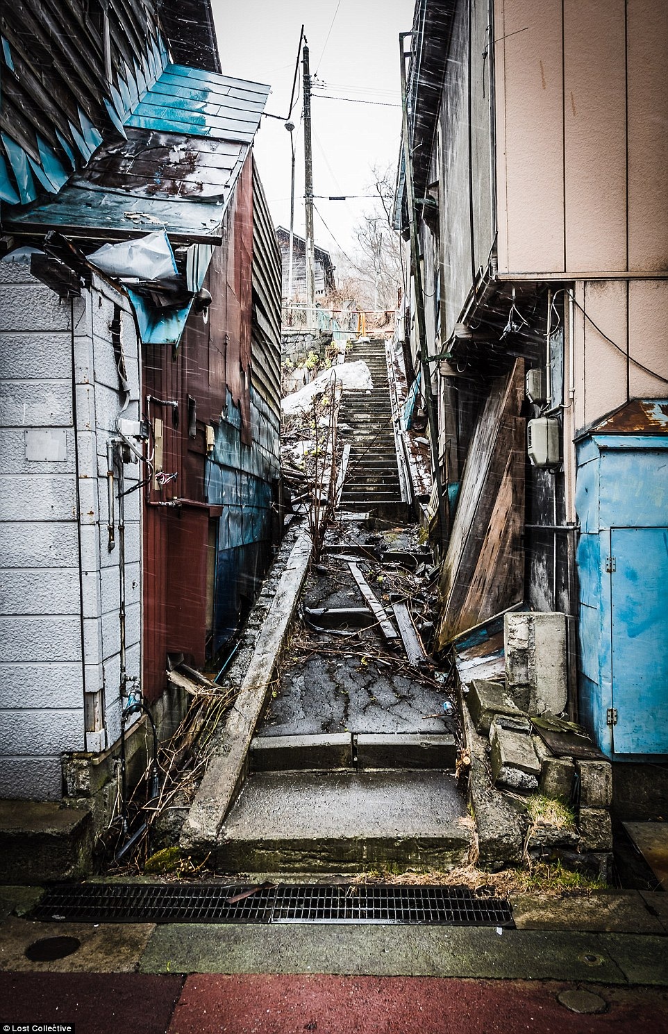 Cầu thang đi chung giữa hai căn nhà phủ đầy bùn đất và rác thải (Ảnh: Brett Patman)