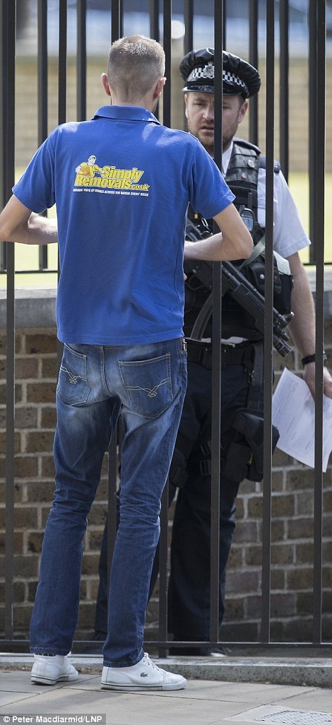 Cảnh sát kiểm tra giấy tờ của nhóm nhân viên tới chuyển đồ cho gia đình ông Cameron trước khi mở cửa cho xe của họ vào trong sân (Ảnh: LNP)