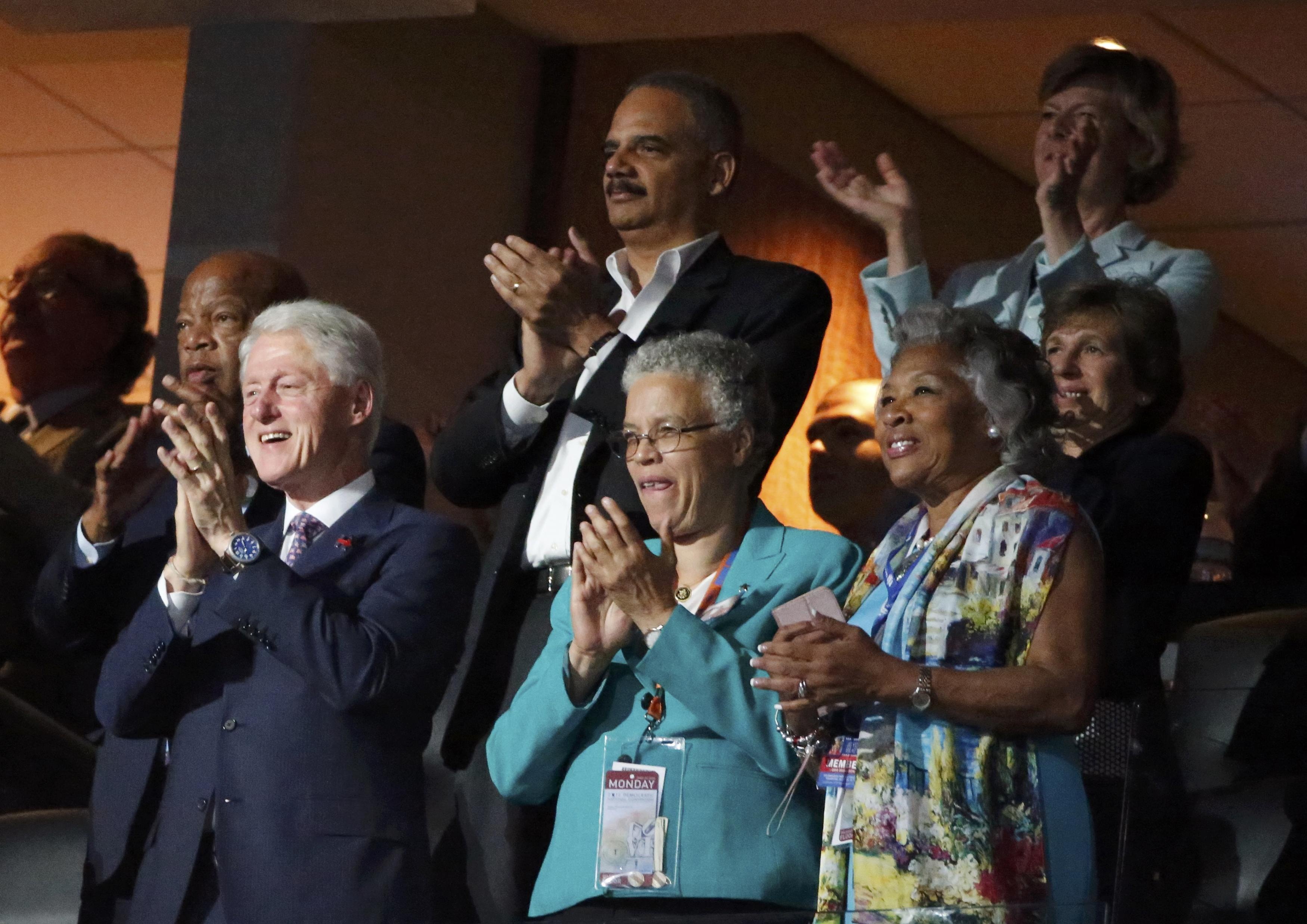 Cựu Tổng thống Bill Clinton (ngoài cùng hàng dưới bên trái) đứng dậy vỗ tay sau khi bà Obama kết thúc bài phát biểu (Ảnh: Reuters)