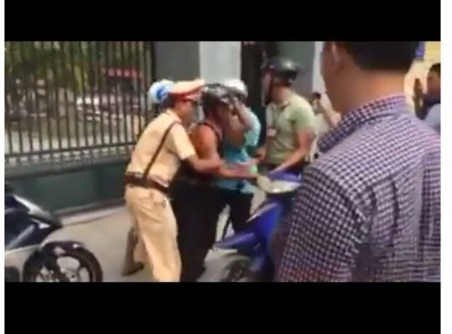 "Người mặc thường phục“ ghì cổ, lăng mạ người vi phạm giao thông là... công an - 2 Việc làm phản cảm sai quy định này diễn ra trước mặt CSGT Kiến Thụy. CSGT không ngăn cản mà còn giúp thanh niên áo xanh khống chế người vi phạm ( ảnh cắt từ Clip)