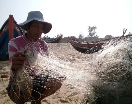 Thuê thợ lặn tìm hiểu vùng biển phát hiện cá chết dưới đáy biển - 1 Ngư dân Hoàng Văn Huần bên tấm lưới trăng tin không có một con cá nào mắc lưới