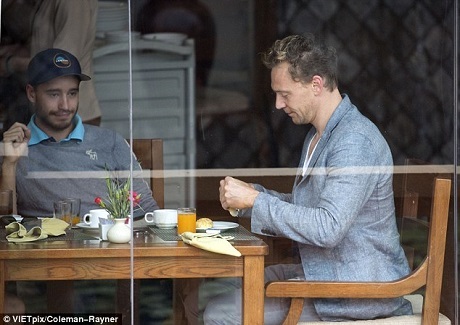 “Và đây là nơi anh ấy đang ẩn náu! Tom Hiddleston có những lọn tóc vàng highlight mới mẻ ở Việt Nam sau khi đốt cháy màn ảnh nhỏ với những cảnh nóng sexy được lan truyền trên mạng” - Daily Mail chú thích ảnh chụp Tom ngồi ăn sáng bên một cửa sổ lớn bằng kính trong suốt.