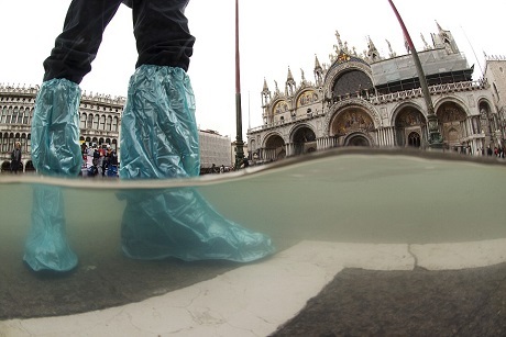 Bức ảnh của tay máy Antonio Busiellocho cho thấy một người đang đi bộ trên quảng trường San Marco ngập nước ở thành phố Venice, Ý.