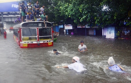 Những thanh niên ở Mumbai, Ấn Độ đang bơi qua đường phố ngập nước hồi tháng 6/2015. Một số thanh niên khác leo lên nóc một chiếc xe buýt. Ảnh của Shantanu Das.