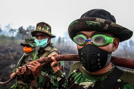 Những người lính Indonesia đang đeo kính bơi để bảo vệ đôi mắt khỏi khói của một trận cháy rừng xảy ra ở làng Rimbo Panjang, Kampar, Indonesia. Ảnh chụp bởi Yt Haryono vào tháng 9/2015. Vào mùa khô của Indonesia, có nhiều vụ hỏa hoạn lớn nhỏ xảy ra, nguyên nhân thường đến từ việc người dân đốt rừng lấy đất làm nông nghiệp.
