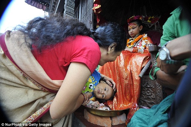 Gặp gỡ những nữ thần sống được người dân Nepal tôn thờ - 3 Hai mẹ con người phụ nữ đang hành lễ trước nữ thần sống Kumari của thành phố Patan.