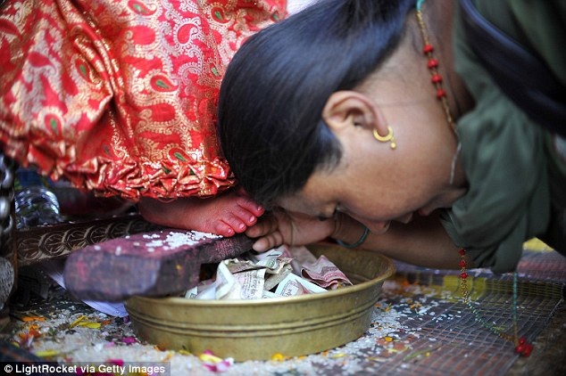 Gặp gỡ những nữ thần sống được người dân Nepal tôn thờ - 5 Một tín đồ đang hành lễ trước nữ thần Kumari.