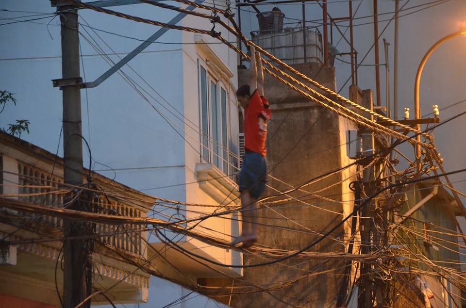Hà Nội: Căng vỏ chăn hứng “người nhện” đu trên dây điện trên phố - 1 Hà Nội: Căng vỏ chăn hứng “người nhện” đu trên dây điện trên phố - 1