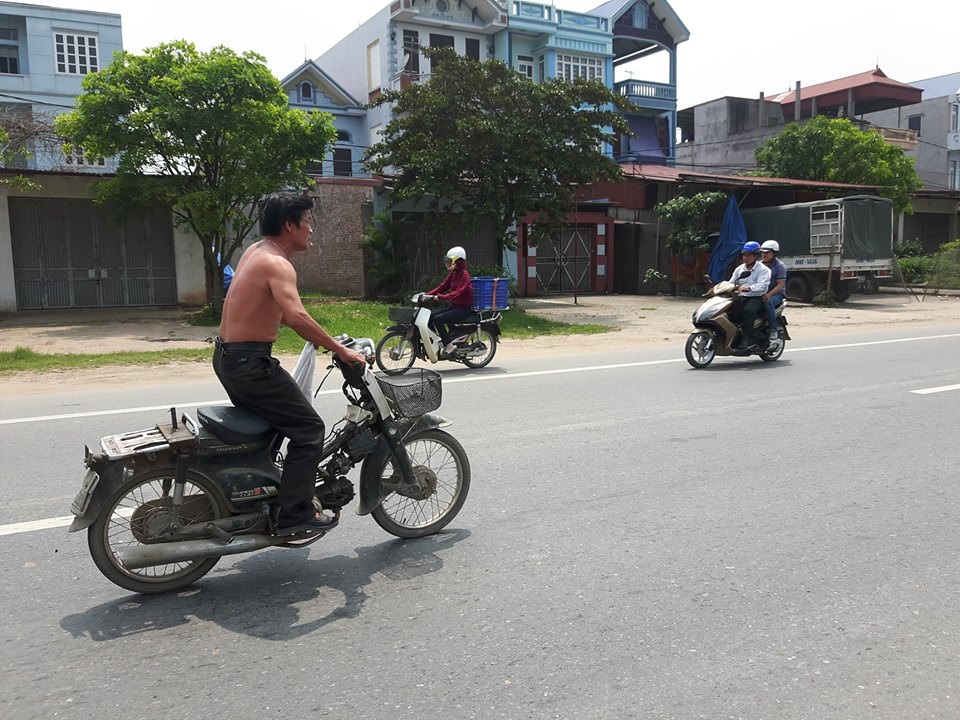 Hà Nội: Kinh hoàng chứng kiến “soái ca” cởi trần đứng lái xe máy - 1 Người đàn ông đi xe máy trong tư thế này suốt quãng đường 5km khiến nhiều người đi đường bị phen hú vía (ảnh cắt từ clip)