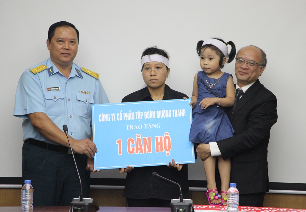 Ông Trần Ngọc Lương (bìa phải) và Đại tá Nguyễn Việt Hùng, Bí thư Đảng ủy, Chính ủy Sư đoàn Không quân 371 trao tặng căn hộ tượng trưng cho chị Trần Thị Hà.