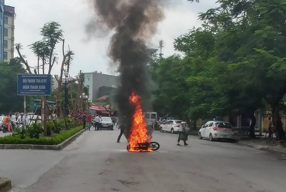 Hà Nội: Va chạm với taxi, xe máy bốc cháy dữ dội - 1 Chiếc xe bốc cháy dữ dội sau cú va chạm với xe taxi.