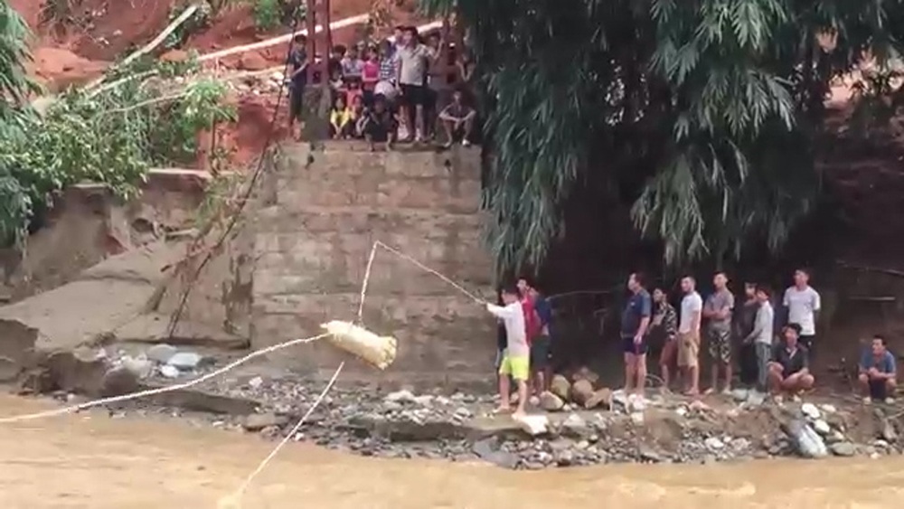 Xem cảnh hàng cứu trợ “đu dây” đến với bà con vùng lũ - 2 Hàng hóa phải đu dây qua sông mới đến tay người dân thôn Sủng Hoảng.
