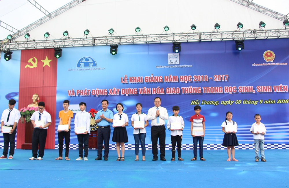 Phó Thủ tướng đội mũ bảo hiểm cho học sinh trong ngày khai giảng - 4 Ông Khuất Việt Hùng - Phó Chủ tịch Chuyên trách Ủy ban An toàn giao thông Quốc gia (thứ 5 từ phải qua) và ông Nguyễn Bá Kiên - Tổng biên tập Báo Giao thông (thứ 5 từ trái qua) trao tặng học bổng cho 10 em học sinh có hoàn cảnh khó khăn và trong gia đình có người thân là nạn nhân TNGT.