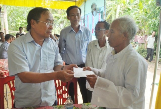 Ông Nguyễn Văn Cao, Chủ tịch UBND tỉnh Thừa Thiên Huế (trái) thăm và hỗ trợ gia đình ông Lê Văn Tưởng bị sét đánh chết