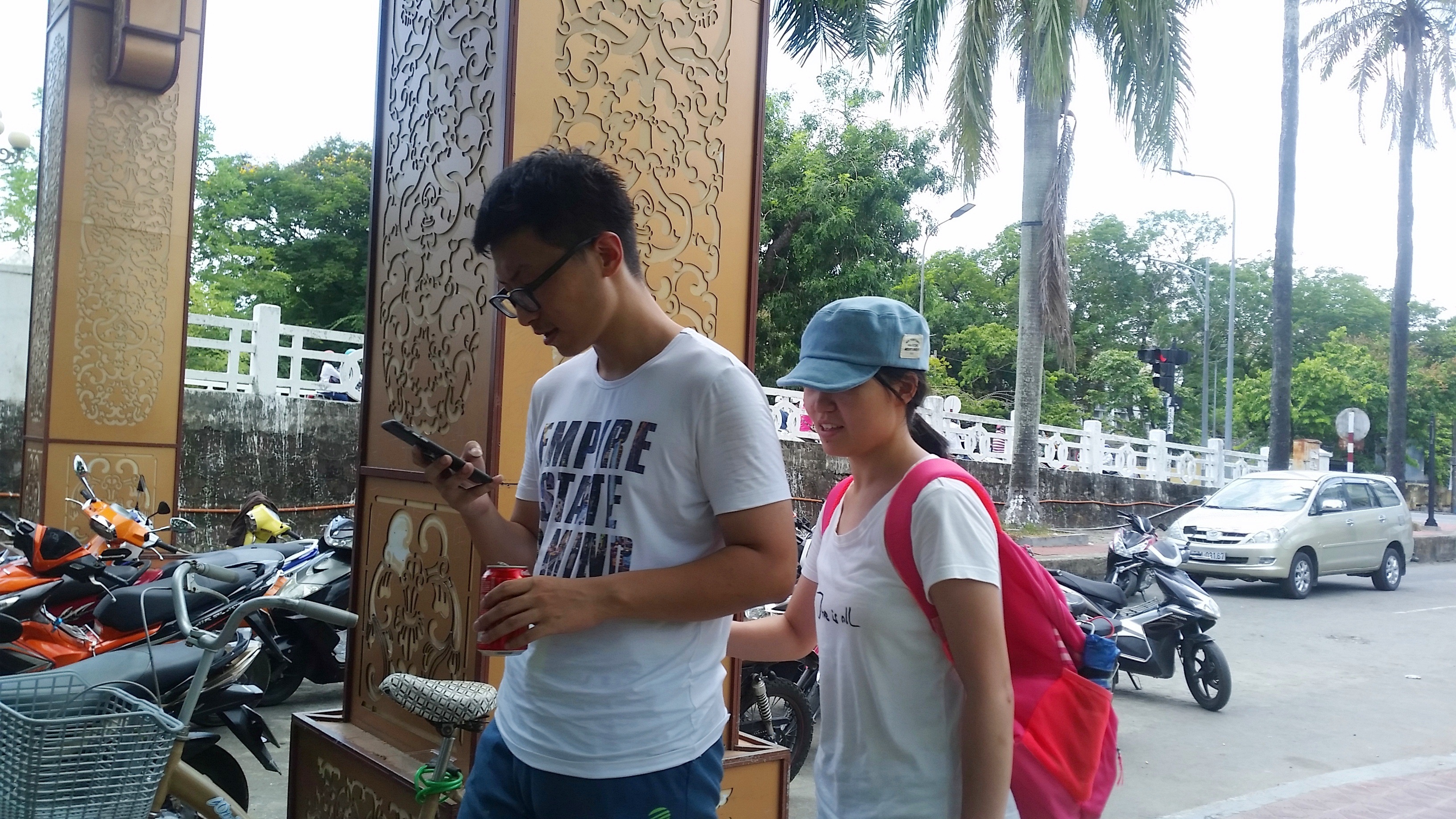 Hai bạn trẻ đi bộ để bắt Pokemon trên điện thoại di động