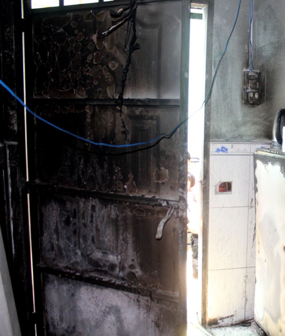 Cánh cửa phòng trọ bị cháy đen sau vụ phóng hỏa