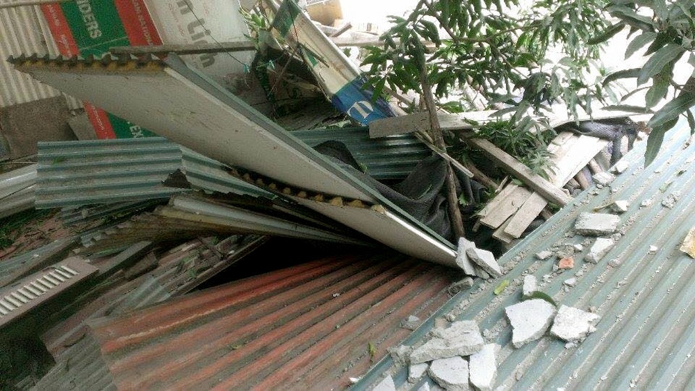 Đình chỉ công trình xây dựng để rơi bê tông vào nhà dân - 1 Bê tông, vật liệu xây dựng chọc thủng mái dãy 3 nhà dân.