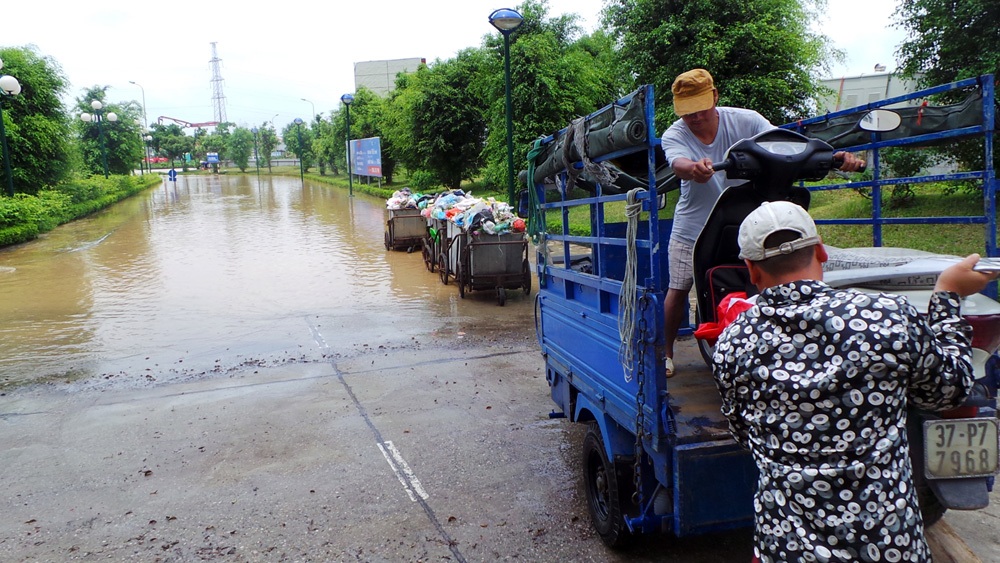 Sáng 26/5, Ban quản lý tòa nhà HH2 đã sử dụng nhiều xe tải để đưa người dân ra khỏi khu vực ngập, kịp giờ đi làm. Một số người dân có xe ba bánh cũng tận dụng cơ hội này để làm thêm.