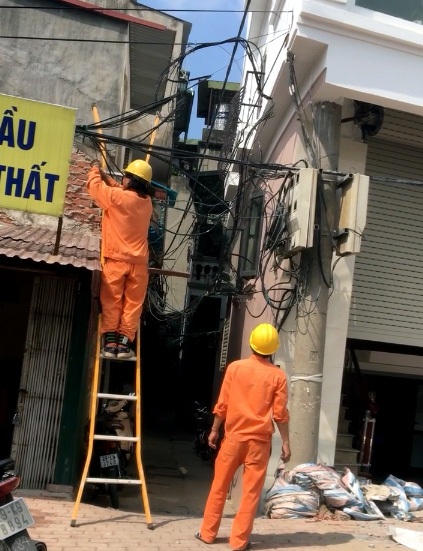 Kỳ lạ cột điện “mọc” xuyên nhà ở Hà Nội - 4 Công nhân điện lực sửa chữa, khắc phục sự cố chập cháy sáng 7/6. (Ảnh: người dân cung cấp)