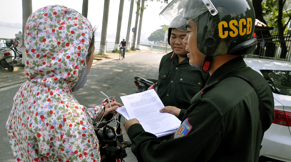 Người Hà Nội ngạc nhiên khi Cảnh sát cơ động tuần tra ban ngày - 9 Người phụ nữ này thậm chí còn không biết quy định phải đội mũ bảo hiểm khi đi xe máy điện. Lực lượng CSCĐ phải giải thích, nhắc nhở người vi phạm chấp hành nghiêm các quy định của pháp luật về an toàn giao thông.