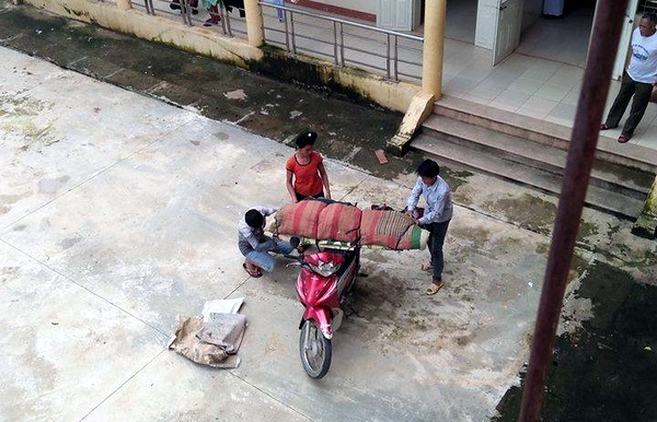 Thi thể bệnh nhân được quấn chăn, đưa bằng xe máy về nhà.