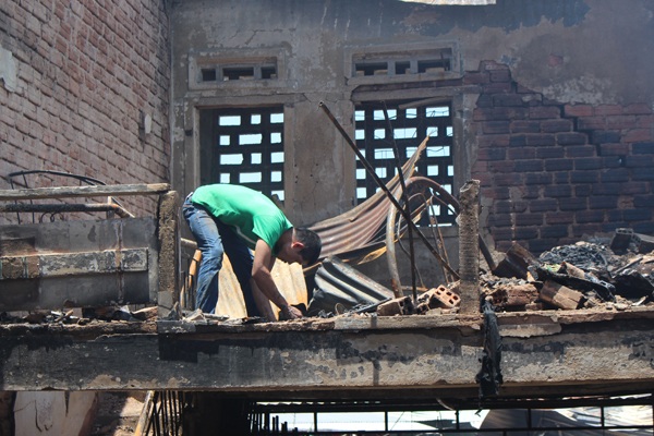 Con trai ông Phước đang bới đống tro tàn mong tìm lại được chút tài sản sản gì đó chưa bị cháy