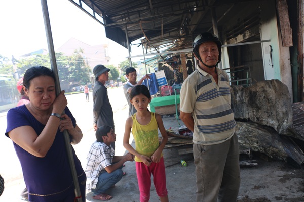 Ông Phước (đội mũ bảo hiểm) xót xa vì toàn bộ tài sản trong ki ốt nhà mình thành đống tro tàn