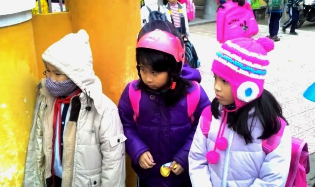Trẻ bị “làm hư” vì nghỉ rét? - 2 Học sinh ở Huế co ro chờ bố mẹ đến đón (Ảnh: Đại Dương)