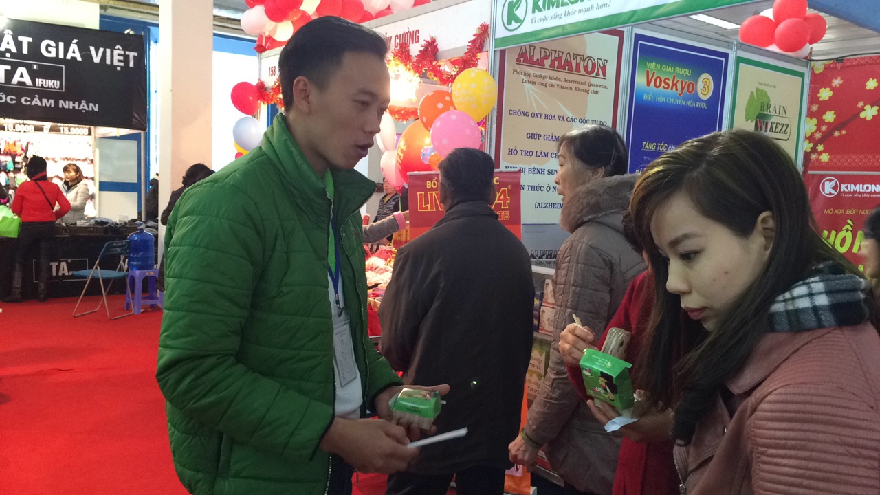 
Nam sinh viên Lê Công Hiếu đang tiếp thị gạo tại hội chợ.
