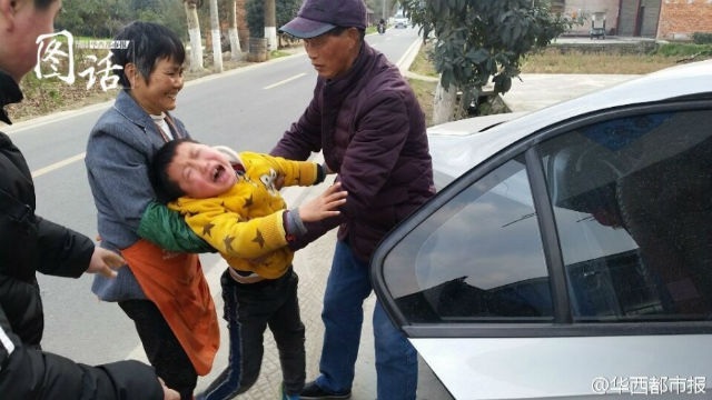 Bé trai 7 tuổi gào khóc cầu xin mẹ đừng đi làm sau nghỉ Tết - 2 cậu bé 7 tuổi gào khóc và nhất định không cho mẹ đóng cửa xe ô tô để lên thành phố, trong khi ông bà cố gắng kéo em lại phía sau