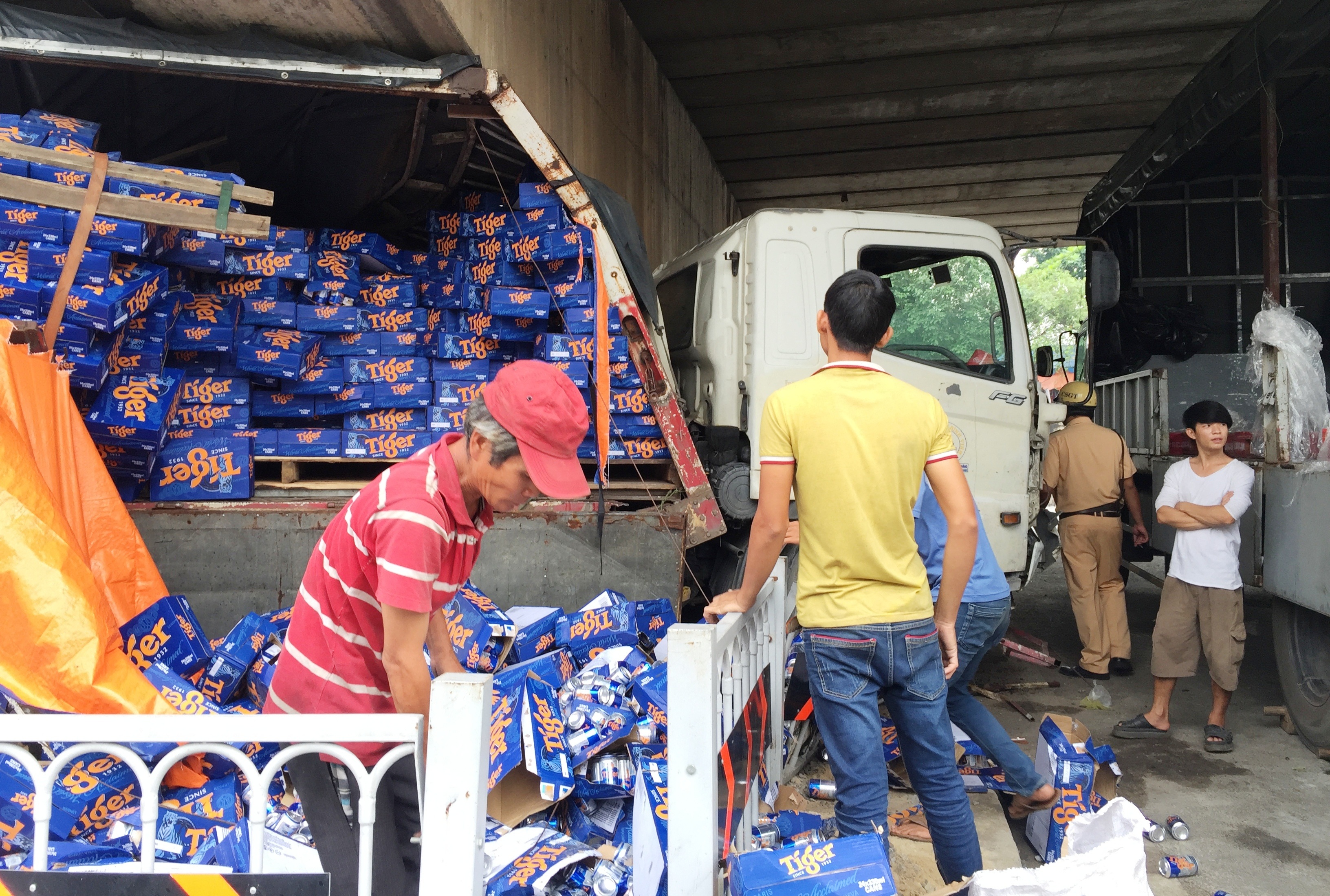 Hàng trăm thùng bia đổ xuống đường, phần đầu và thùng xe tải bẹp dúm.