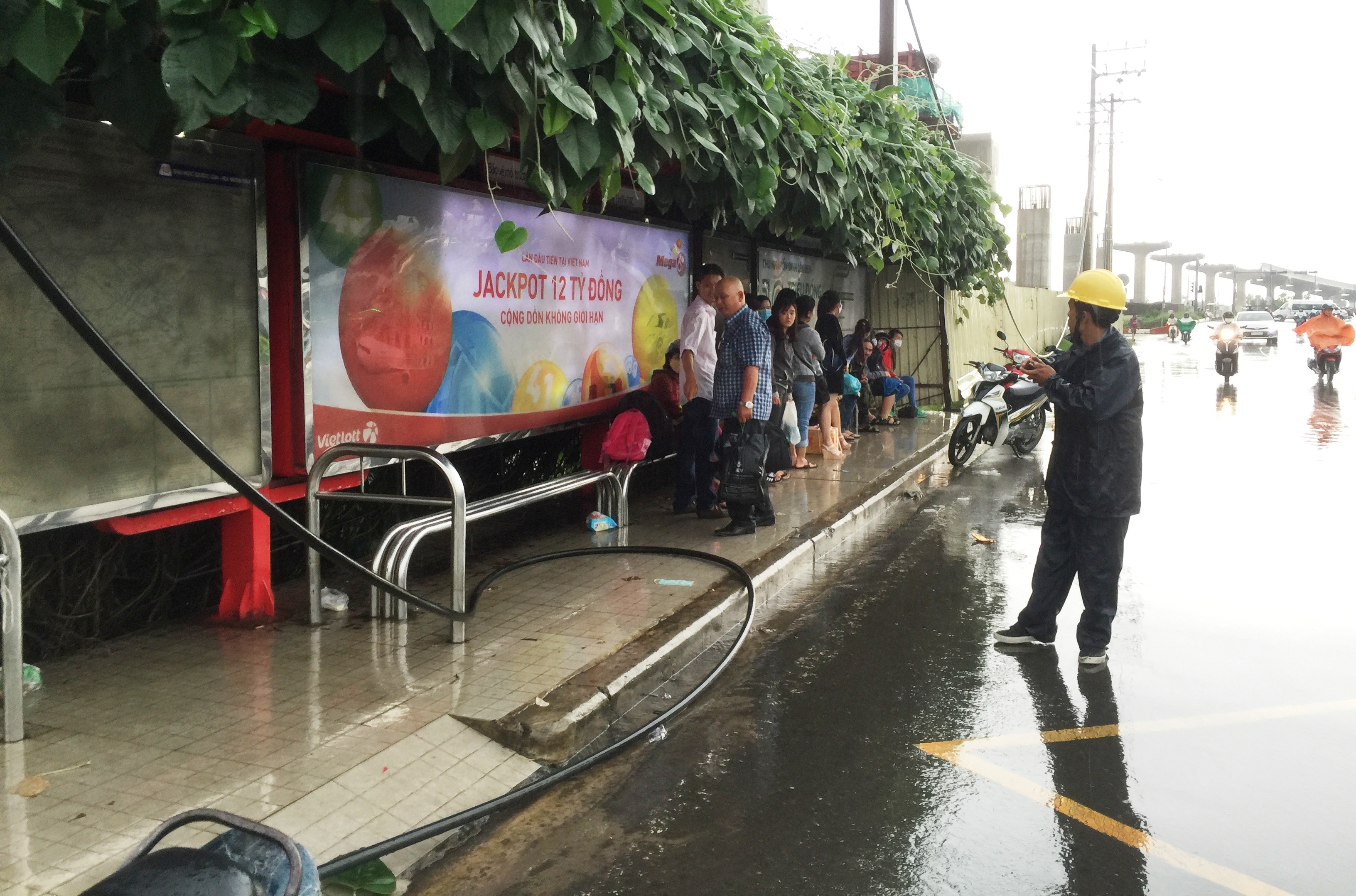 
Dây điện đứt ngang, toé lửa rơi xuống đường, ngay sát những người dân đang trú mưa.
