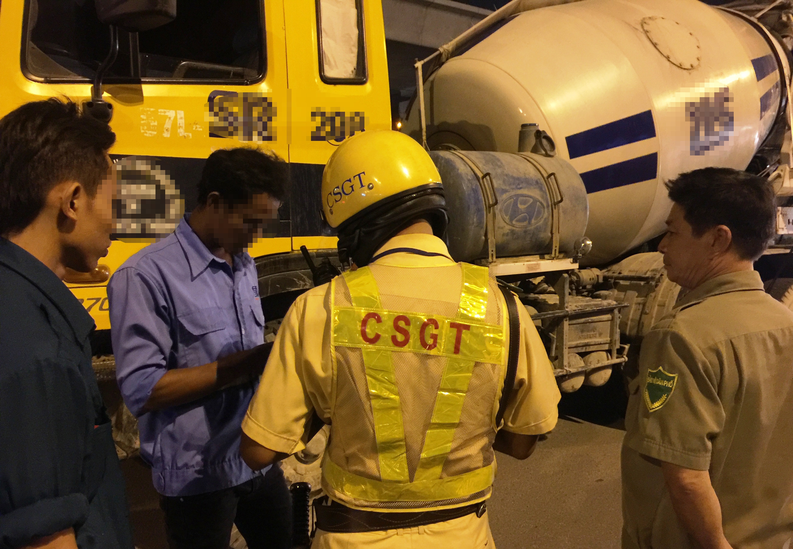 
Tài xế Ngô T. L. (áo xanh, đứng giữa) điều khiển xe bồn chở đầy bê tông nhưng trong hơi thở có nồng độ cồn lên đến 0,297 miligam/lit khí thở.
